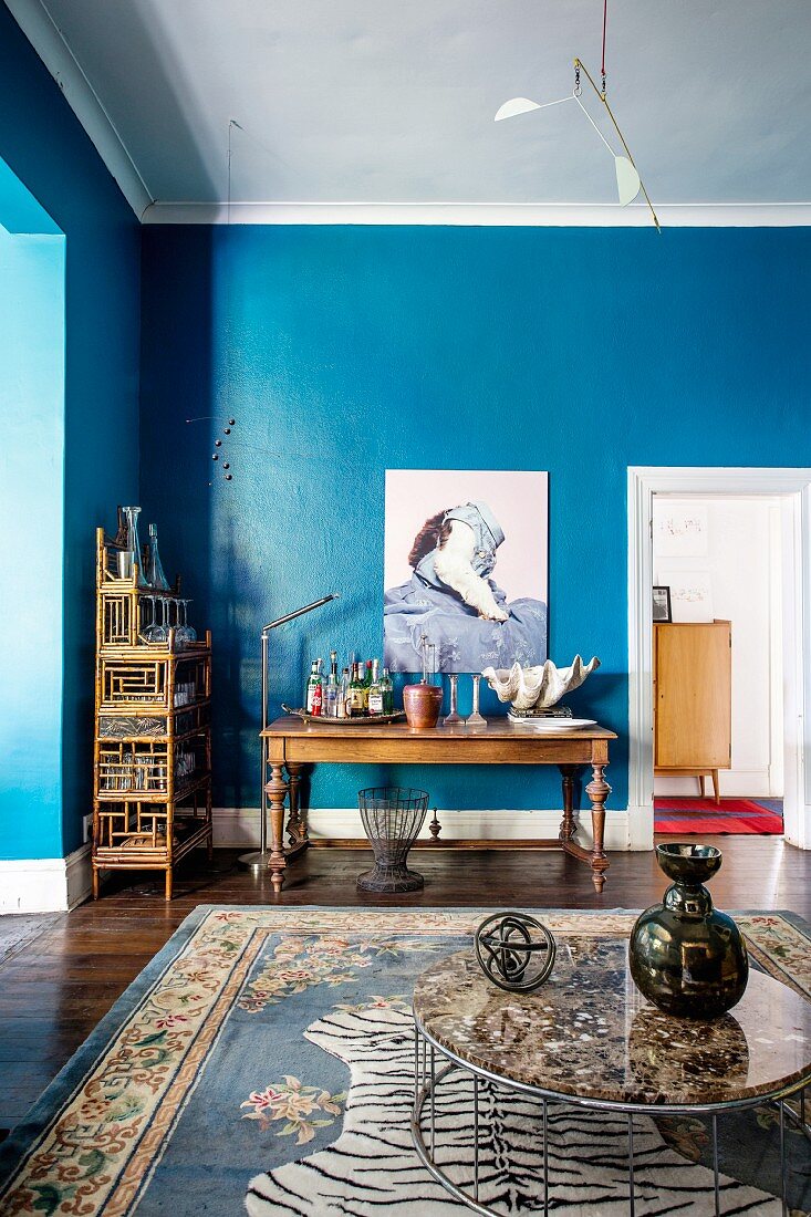 Wohnzimmer mit blauer Wand und Möbeln im Stilmix