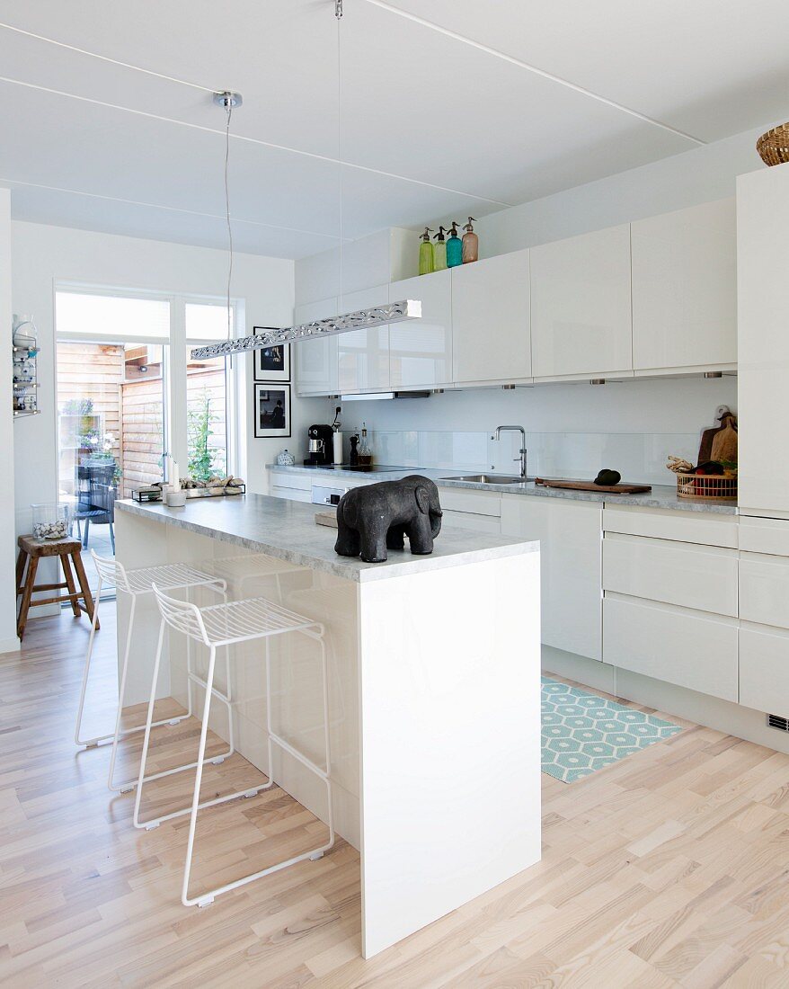 Elephant ornament on island counter in white fitted kitchen