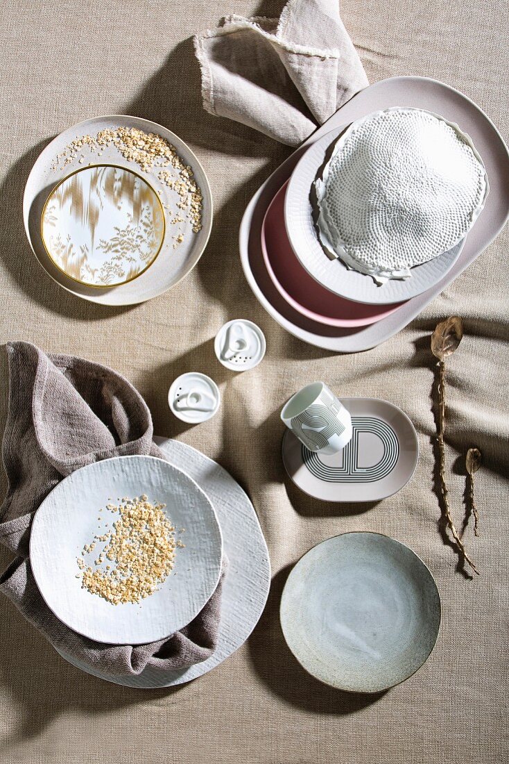 Fine ceramic crockery in powdery shades on linen tablecloth