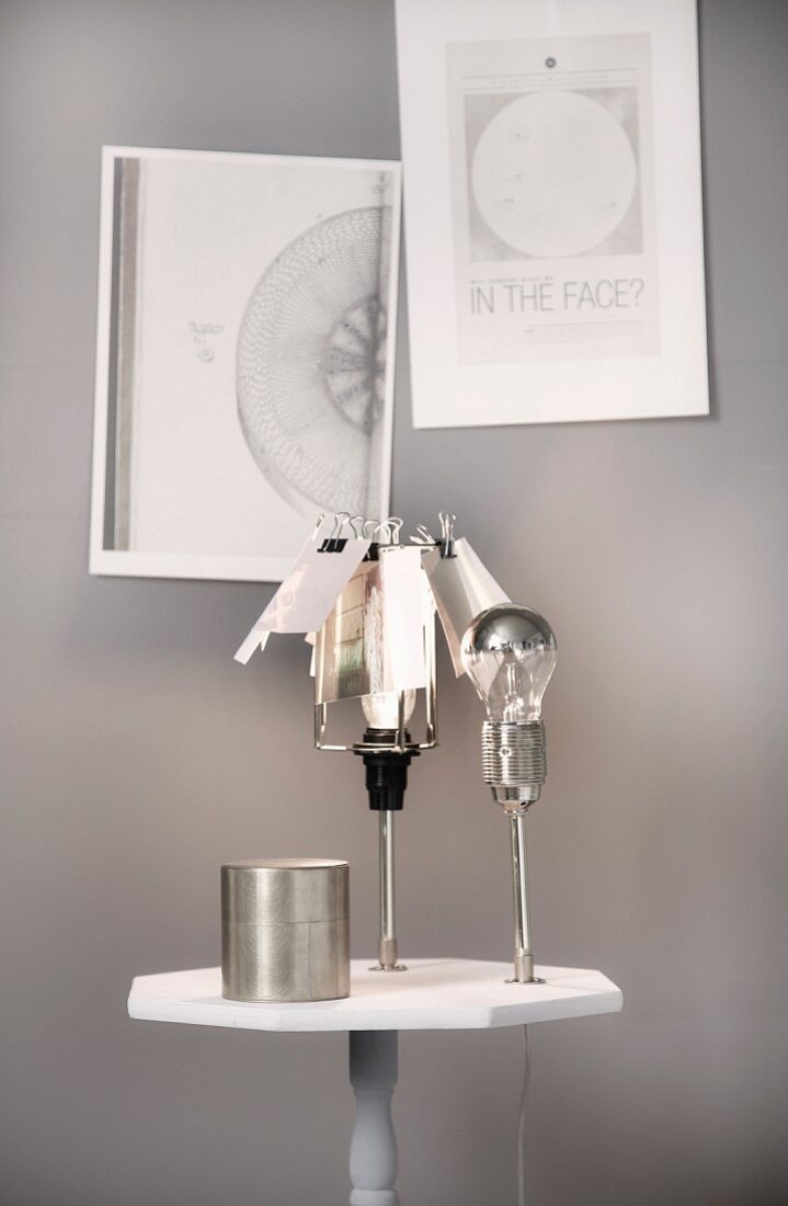 Selbstgemachter Tisch mit drei Leuchten vor grauer Wand