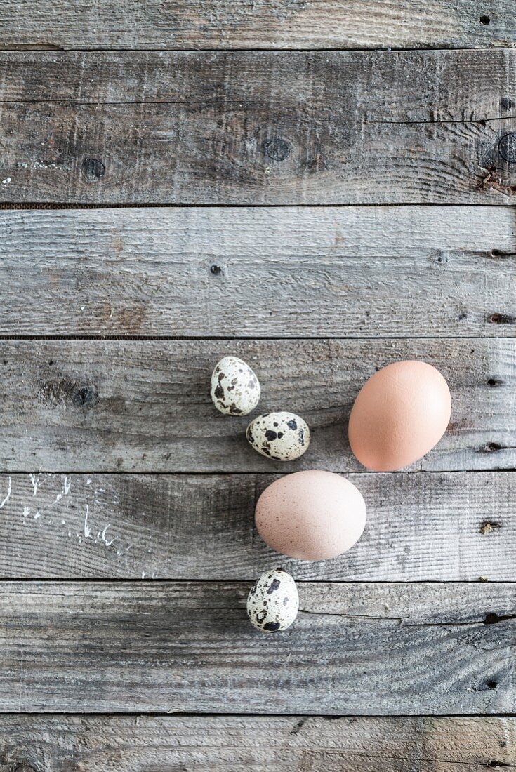 Hens' and quails' eggs on weathered wood