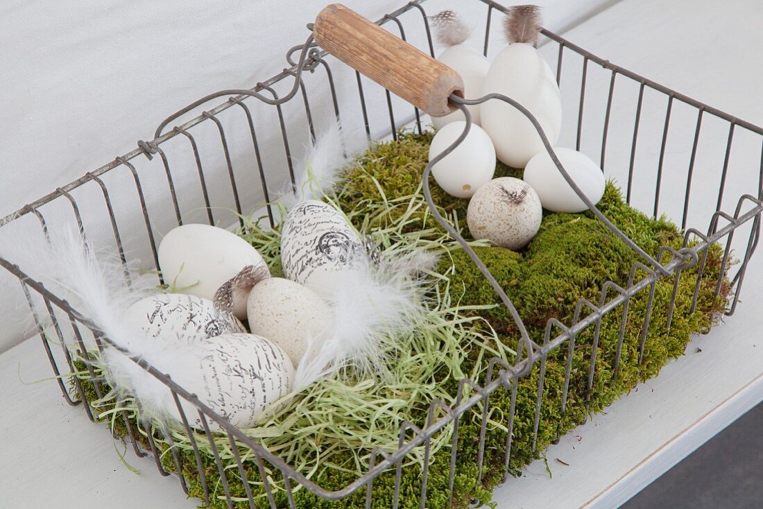 Lettered eggs in Easter nest of moss in metal basket