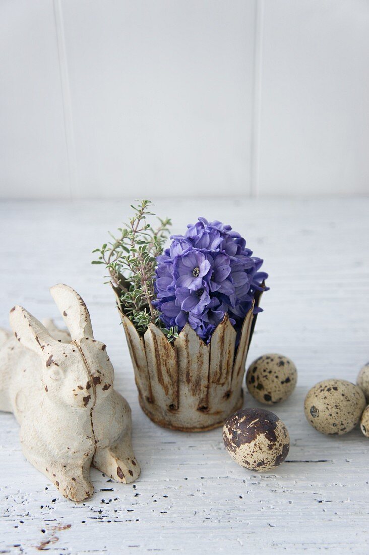 Easter bunny next to blue hyacinth and thyme in metal crown