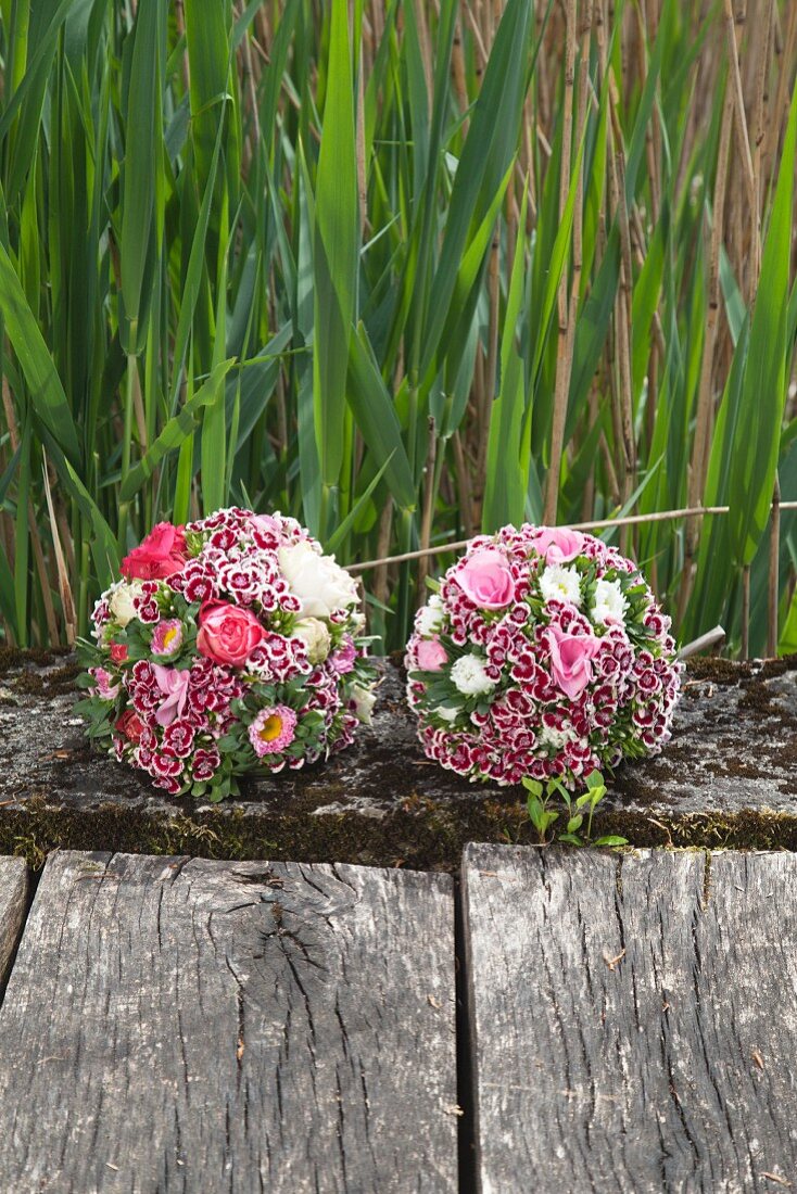 Two flower balls made from sweet Williams, roses, asters and hydrangeas