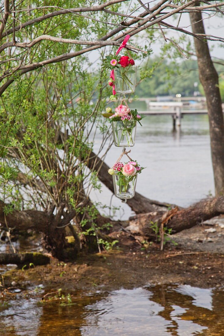 Blumenampel mit Rosen und Bartnelken hängt am Ufer