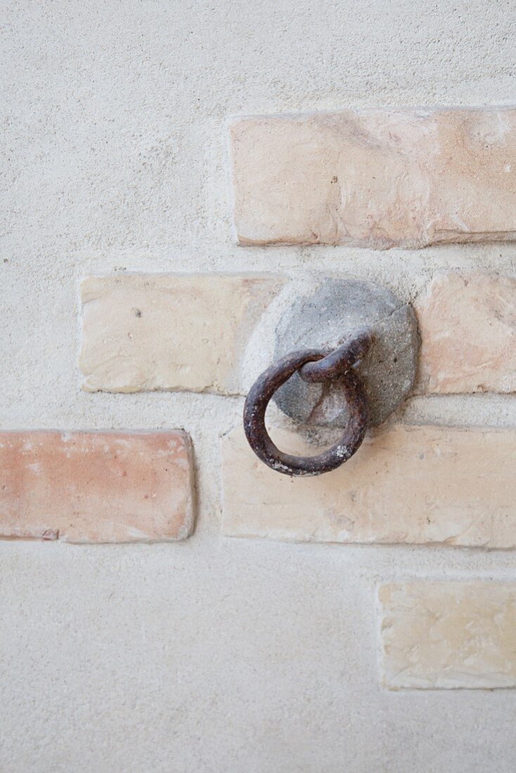 Rustic iron ring attached to concrete and brick wall