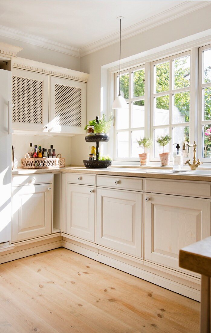 Helle Landhausküche mit klassischen Sprossenfenstern