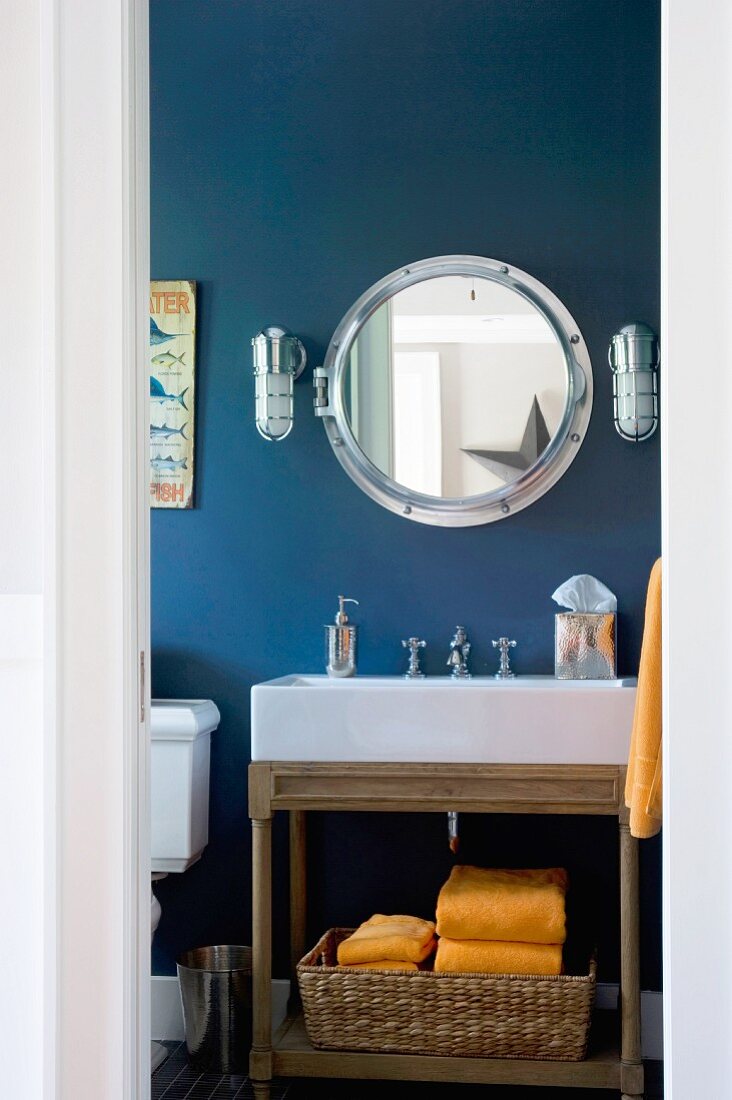 Blick ins Badezimmer im nautischen Stil mit Bullaugen-Spiegel