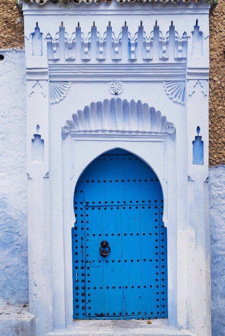 Ornate portal with traditional blue door in Morocco