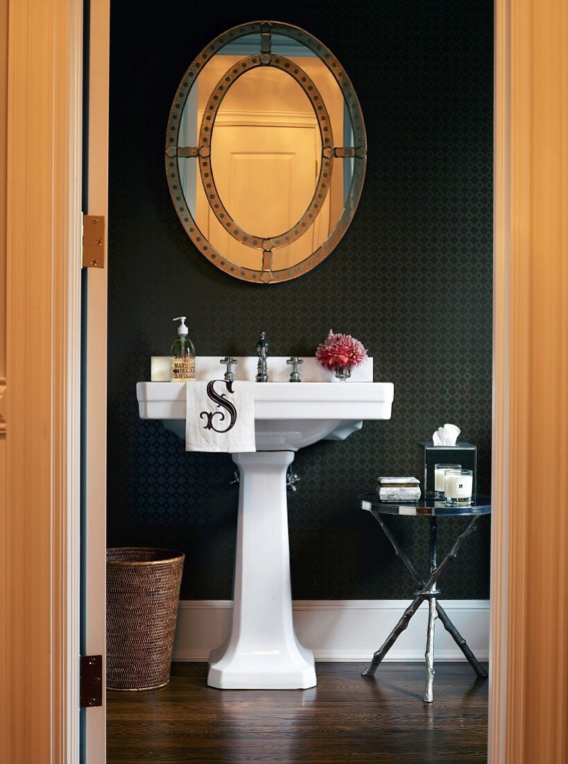 Pedestal basin against black wallpaper in elegant bathroom