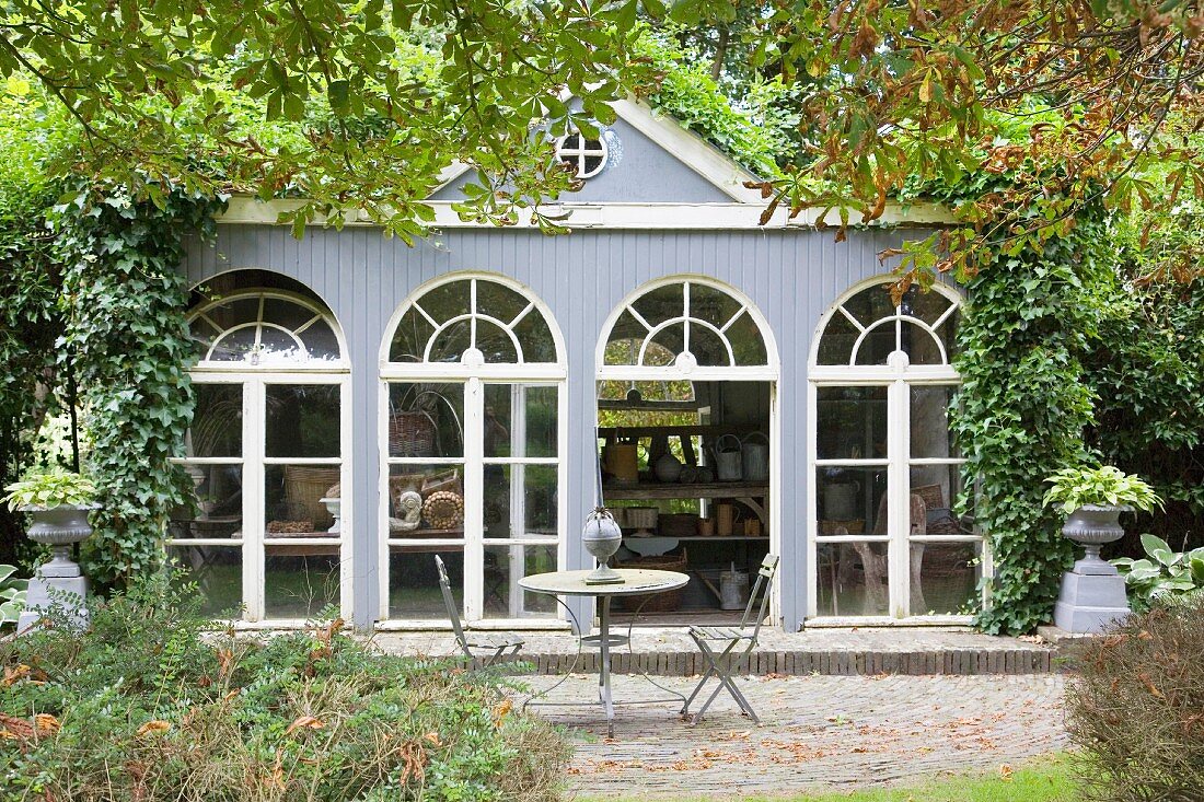 Terrace adjoining orangery with arched windows