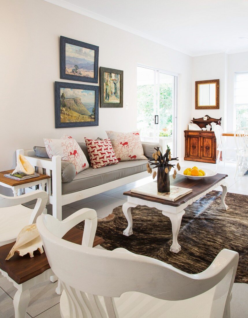 weiße Holzmöbel im Wohnzimmer mit Kuhfellteppich