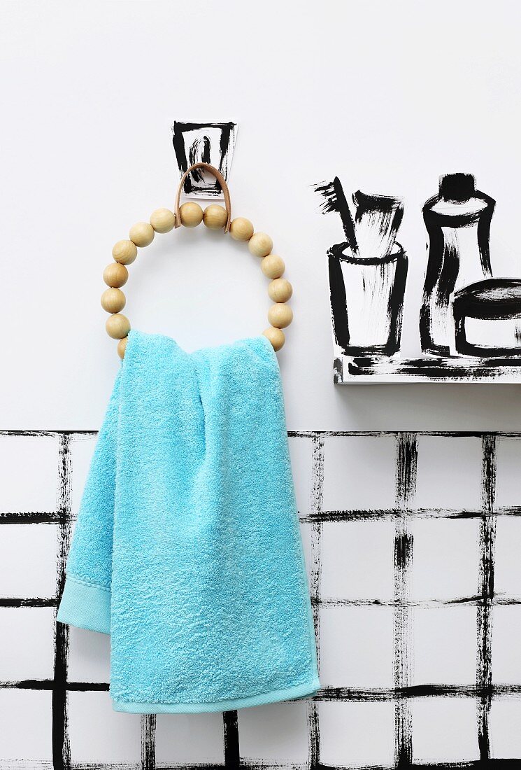 Selbstgemachter Handtuchhalter aus Holzperlen an gemaltem Bad