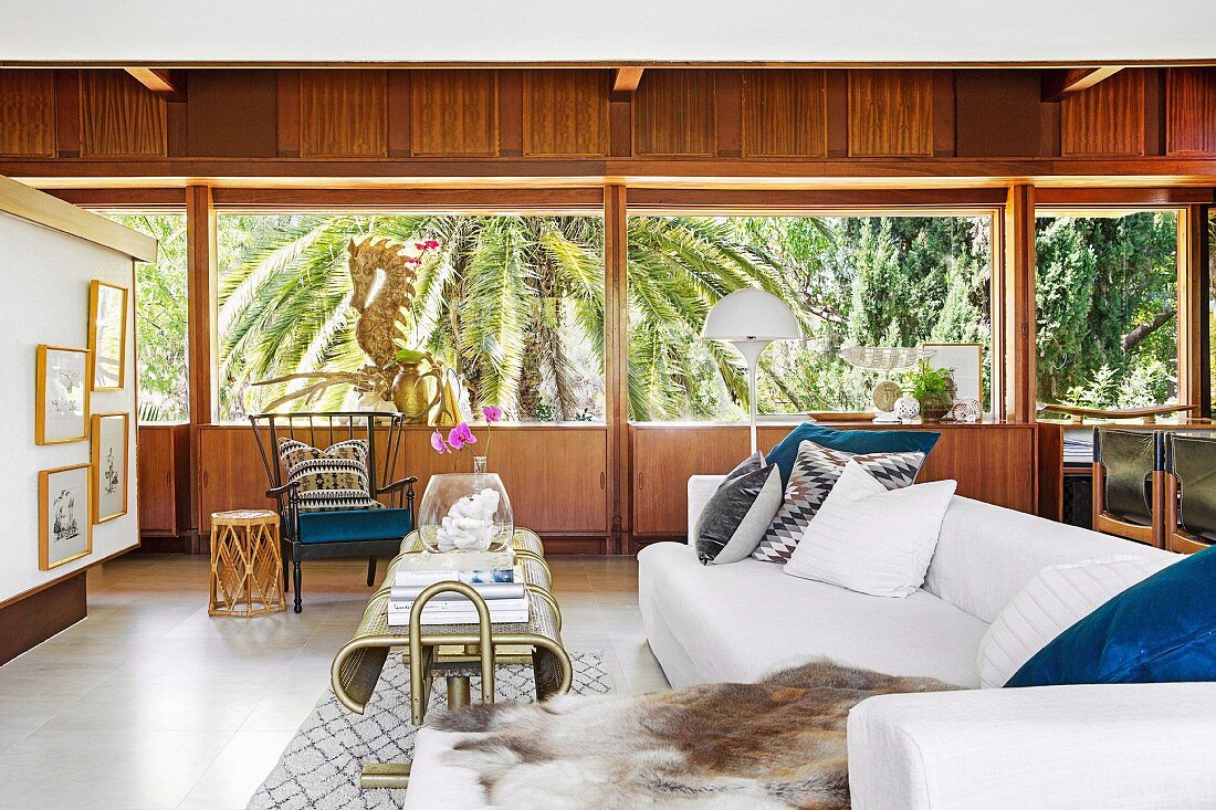 Lounge mit Holzverkleidung und Blick auf Palmen