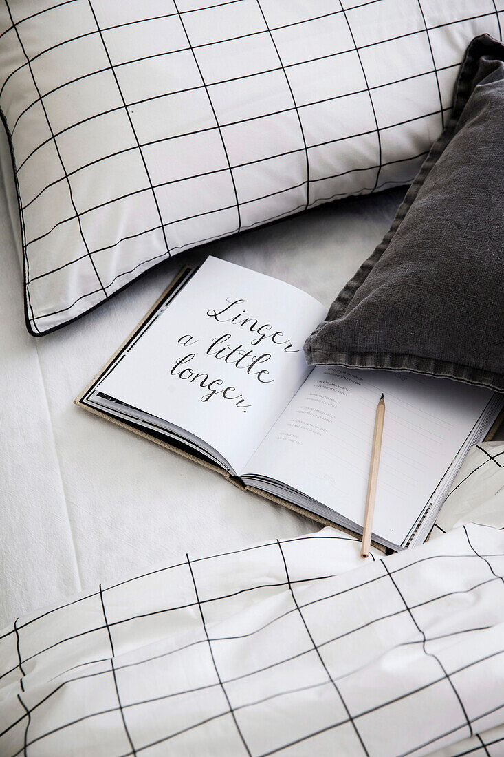 Aufgeschlagenes Buch auf dem Bett mit grafischem Bezug