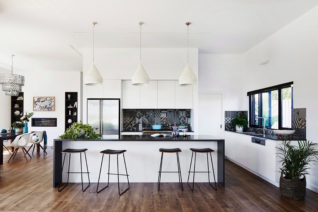Kitchen with kitchen counter and bar stools in an open, elegant living area