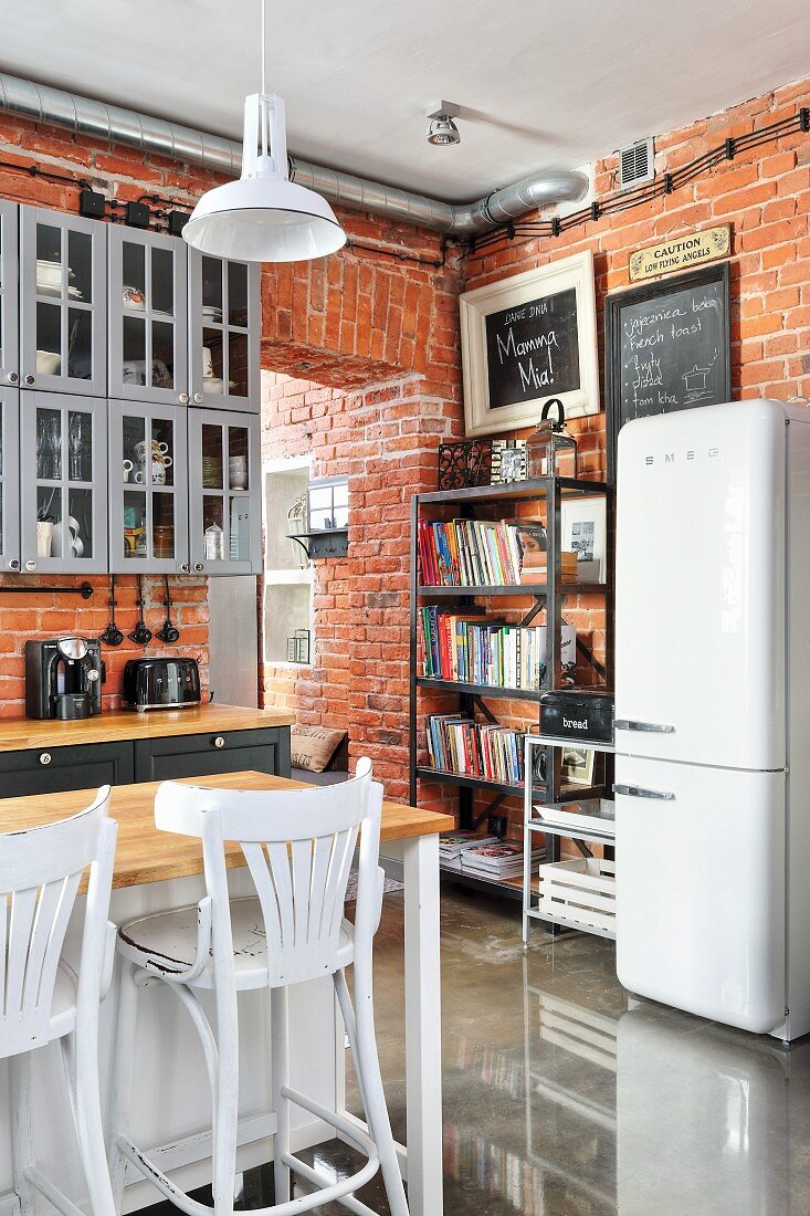 Küche im Industriestil mit Backsteinwand und Bücherregal