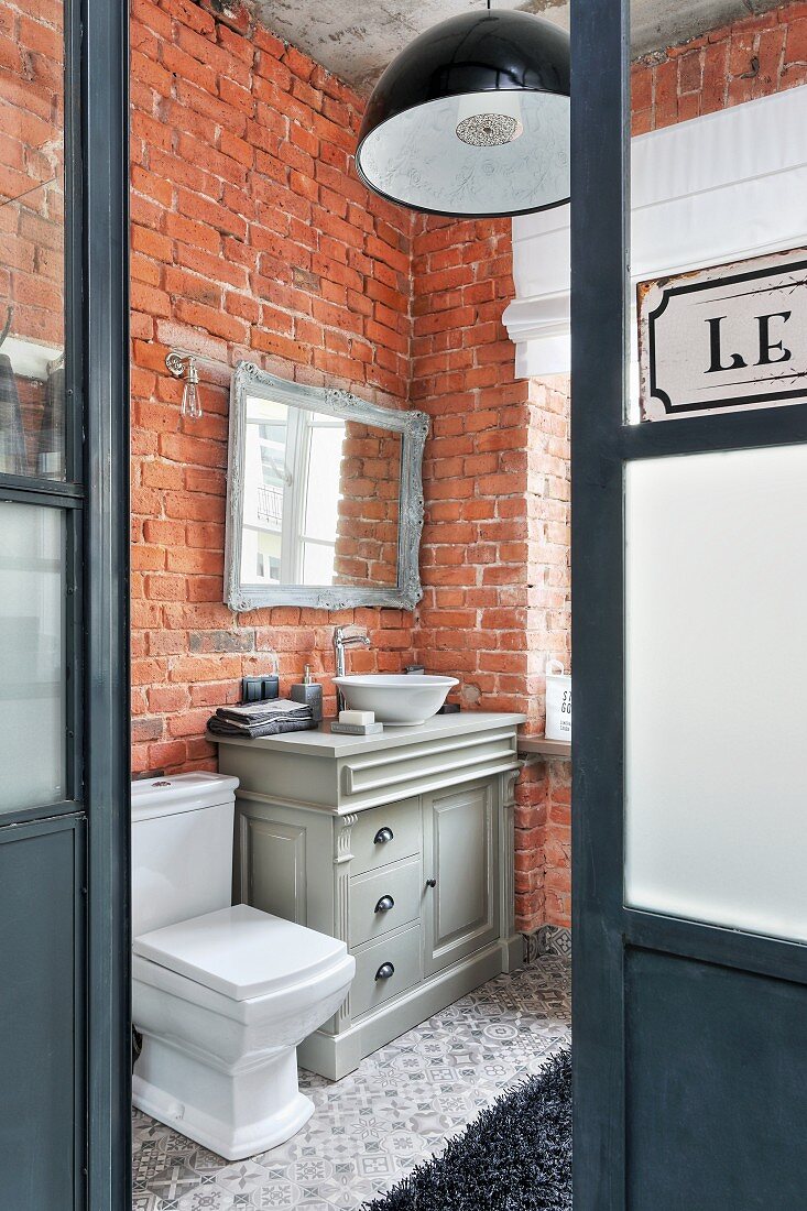 Vintage-style furnishings and brick walls in bathroom