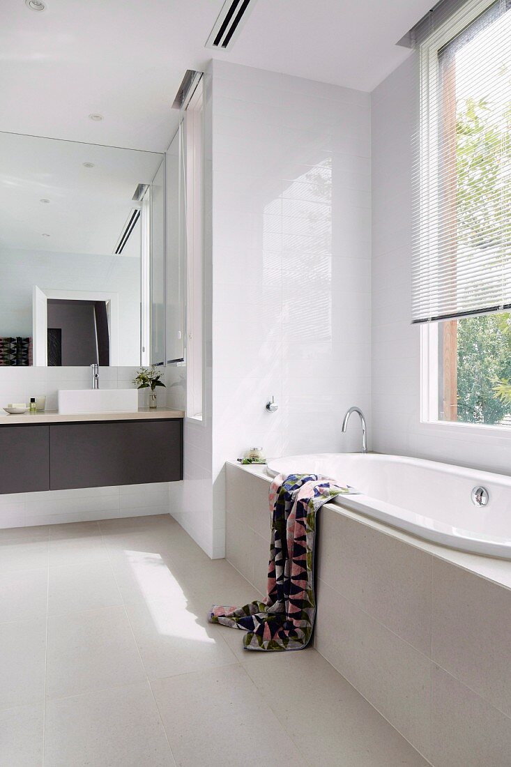 Modern white bathroom with black vanity unit