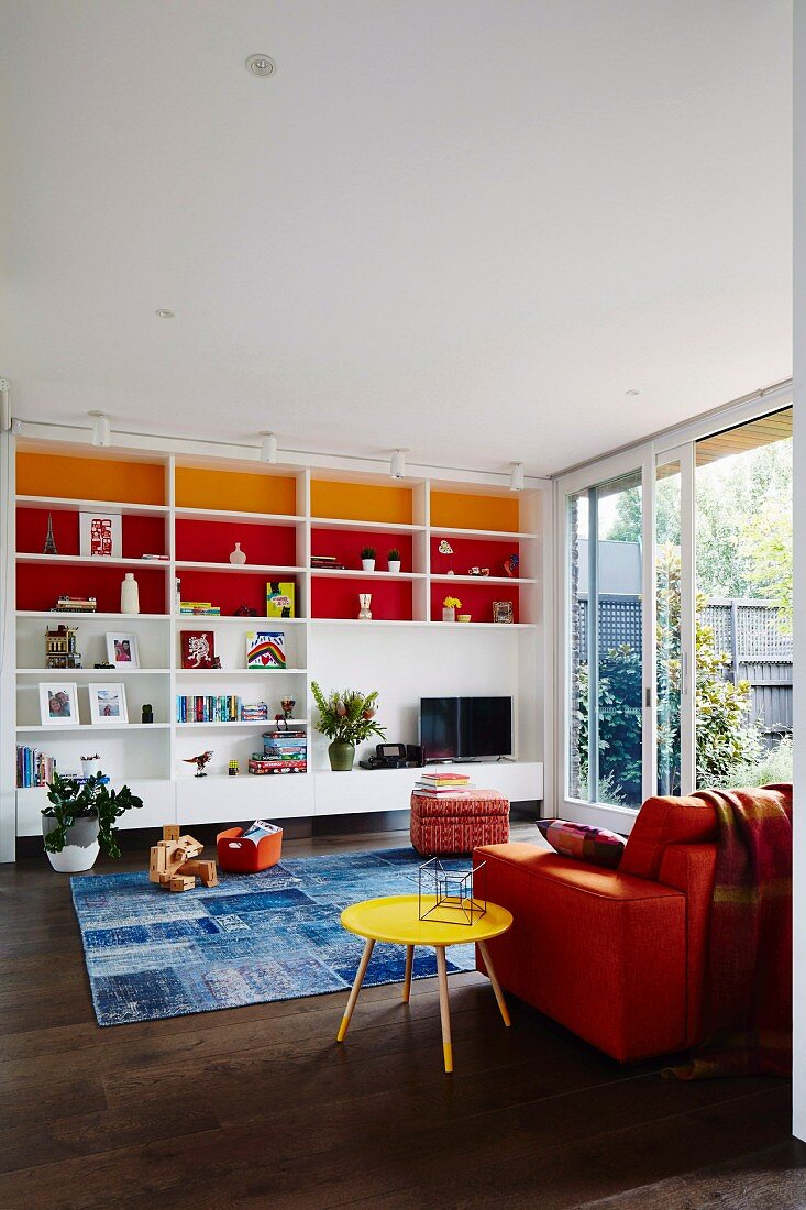 Wohnzimmer mit farbigen Regalrückwänden und bunten Möbeln