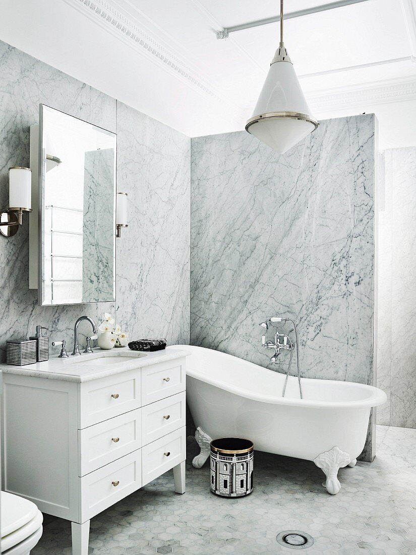 Vanity unit and free-standing tub, in elegant bathroom with marble paneling