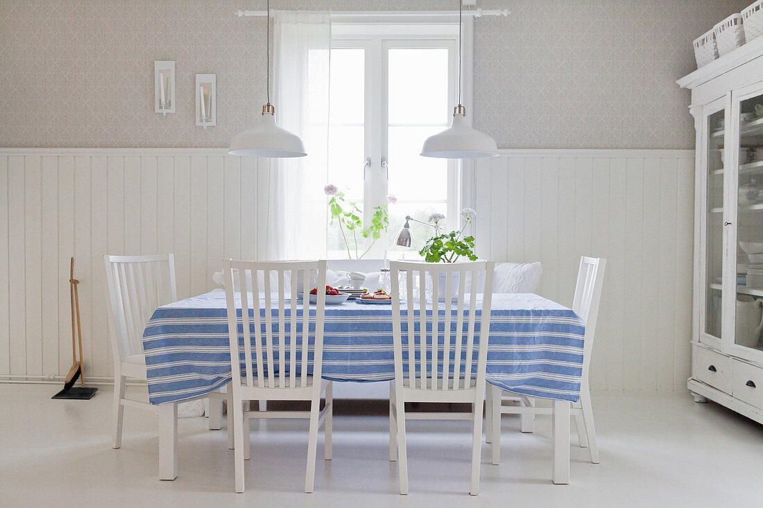 Blue-striped tablecloth on table in rustic dining room