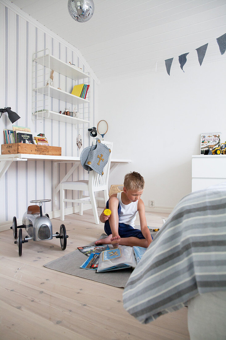 Boy playing in white and blue bedroom