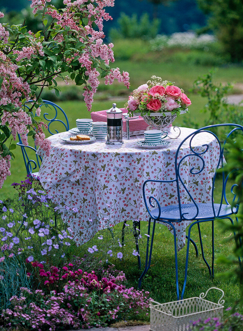 Tisch mit Gesteck aus Rosa (Rosen), Paeonia (Pfingstrosen)