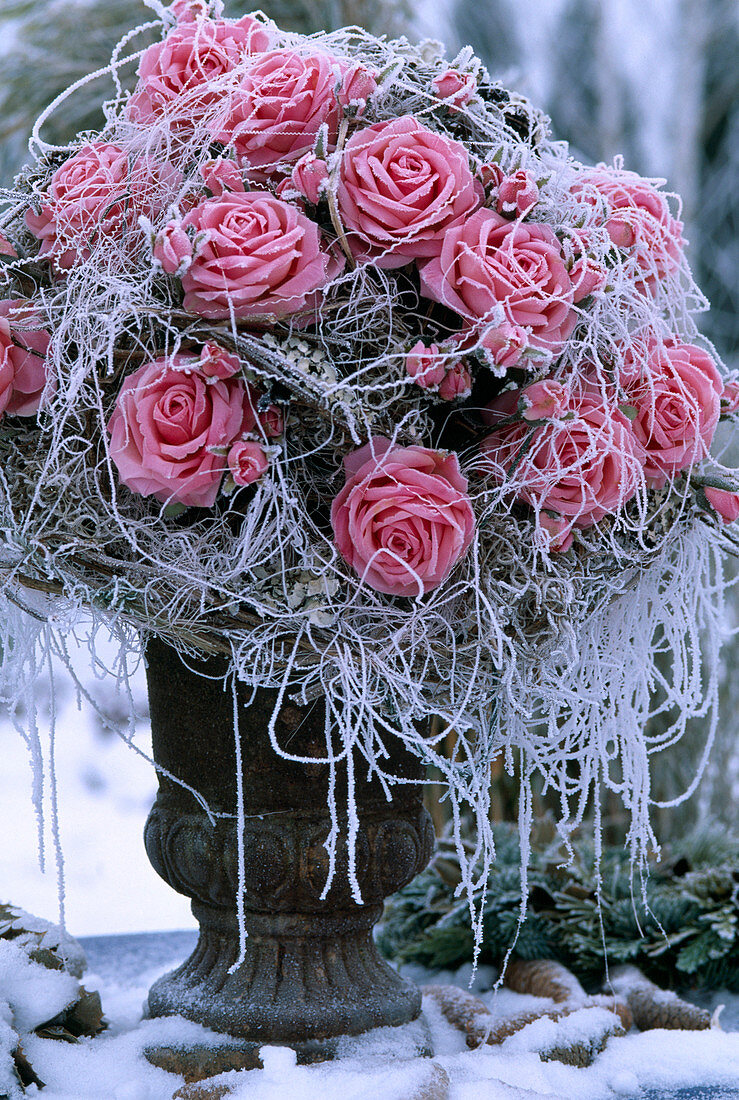 Vase with rose bouquet of silk in hoarfrost