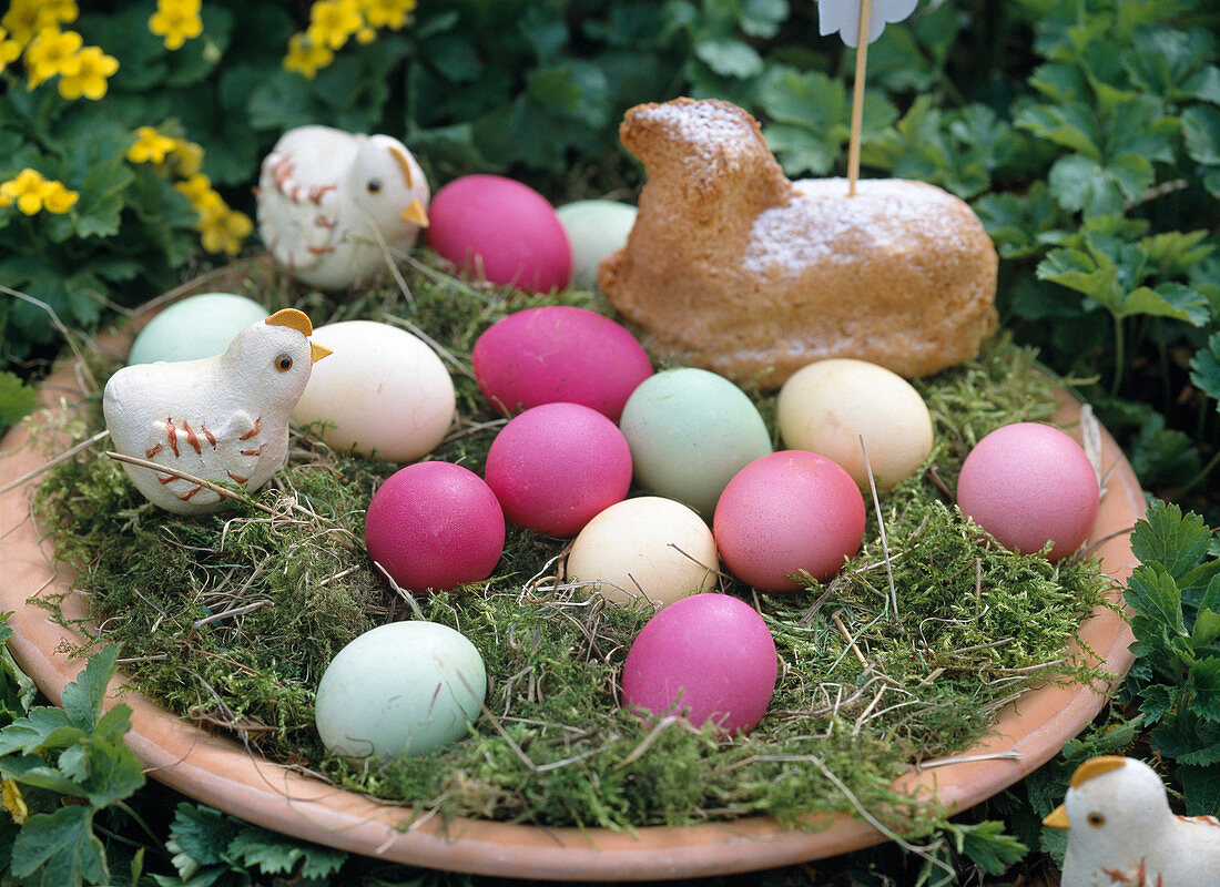 Easter nest with colored eggs, chicks and Easter lamb