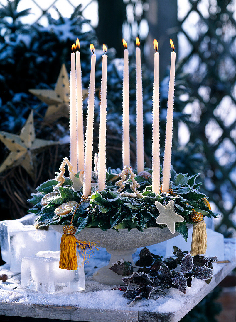 Hedera wreath in the cup with stick candles, ice stars and mahonia
