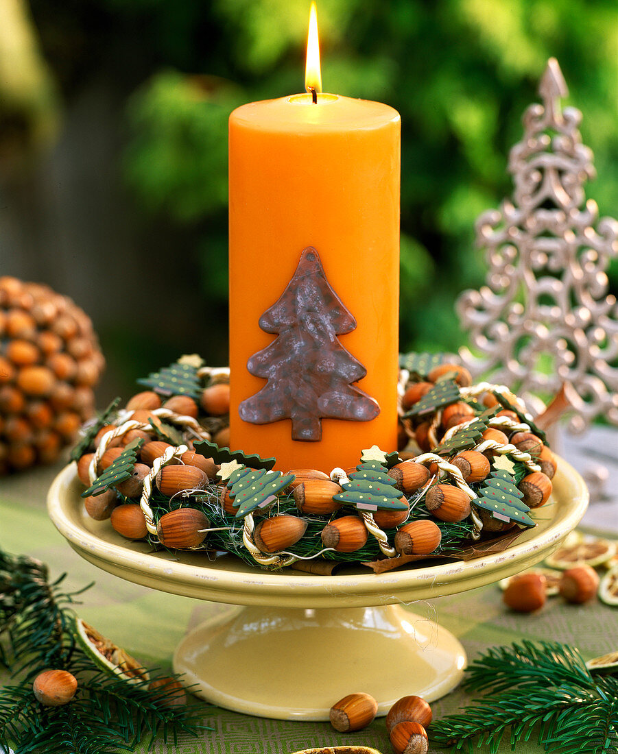 Kuchenplatte mit Haselnußkranz und Kerze