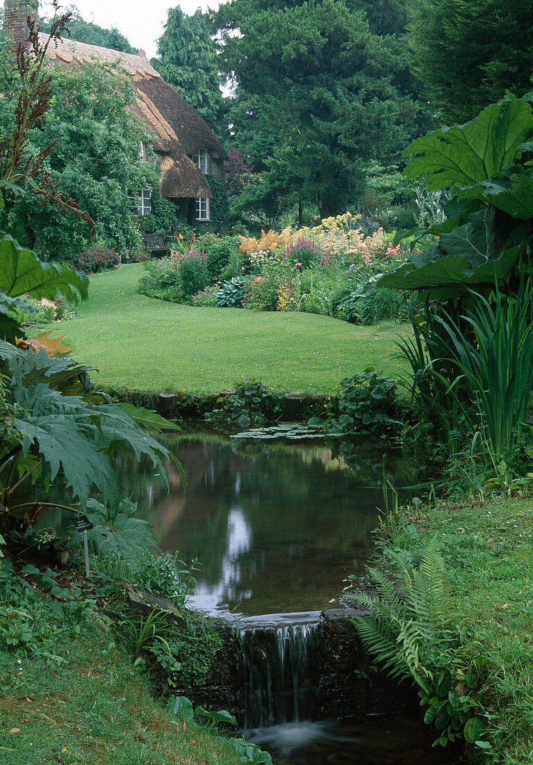 Bachlauf im Landhaus-Garten, Blick über Rasenfläche zum Staudenbeet