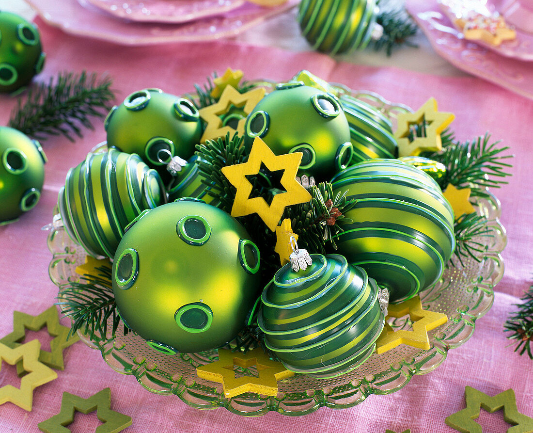 Christmas baubles and wooden stars on glass plate