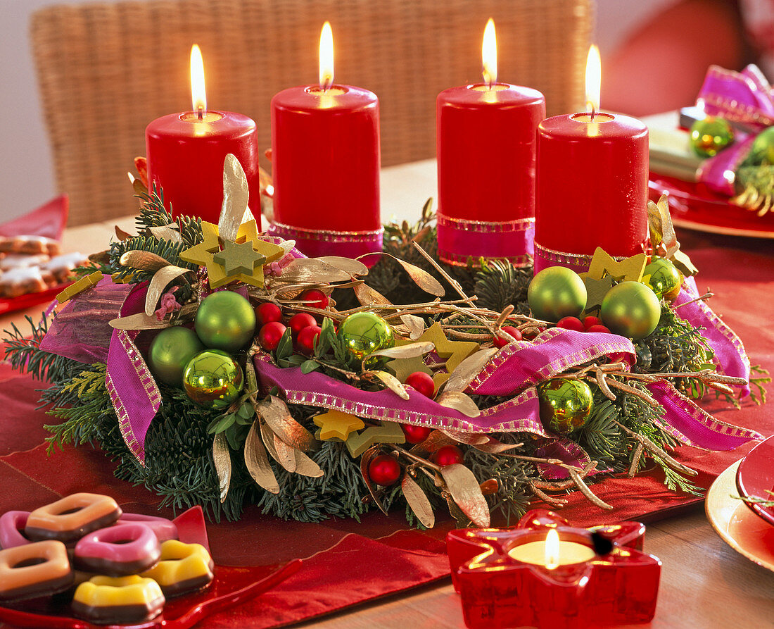 Advent wreath made of mixed green with tree decorations, mistletoes