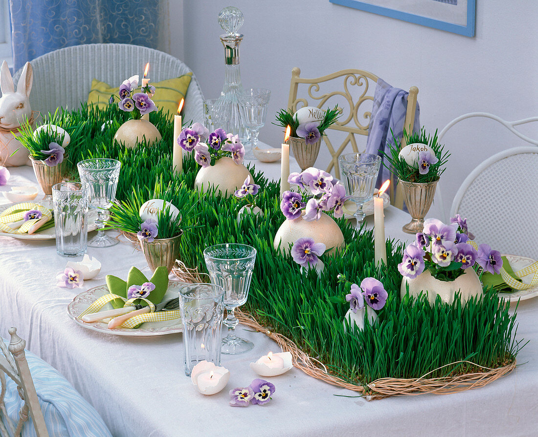 Festive table decoration with grass runner and pansy flowers