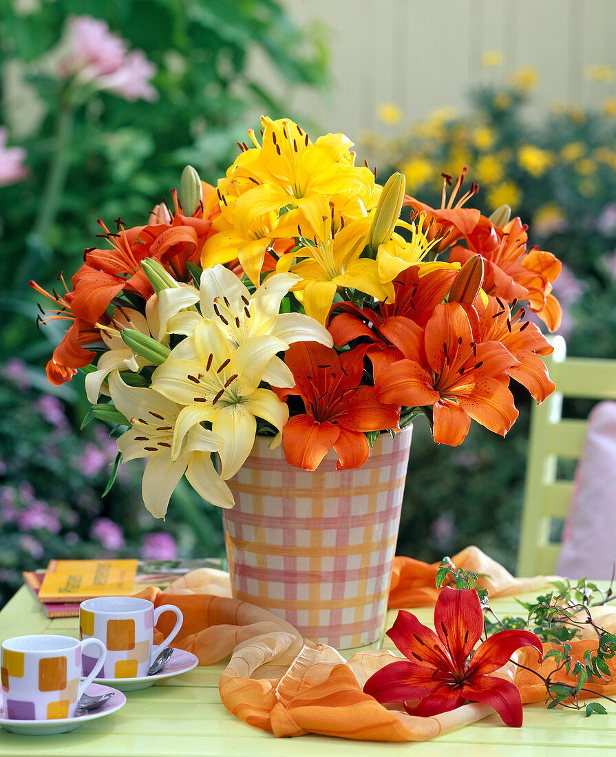 Bouquet of Lilium in yellow, red and orange in checkered vase