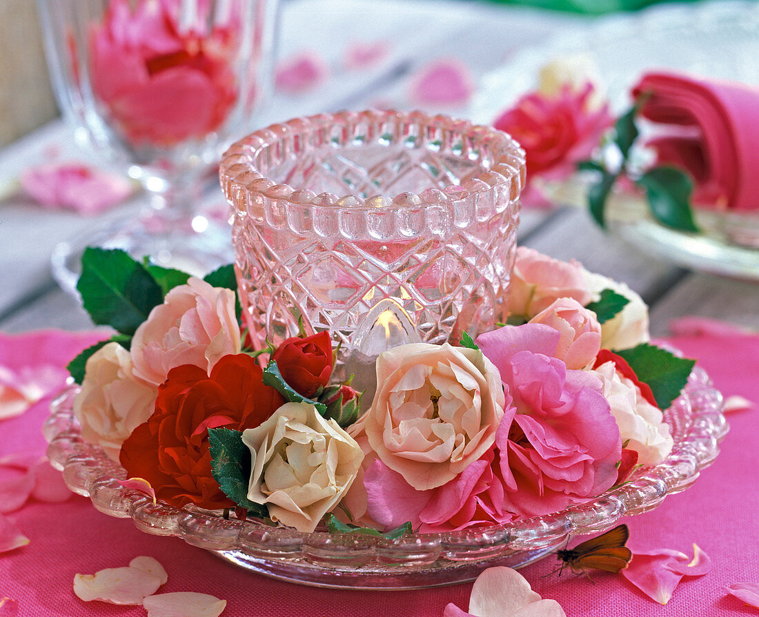 Kranz aus Blüten von Rosa (Rosen, hellrosa, pink und rot) um Windlicht