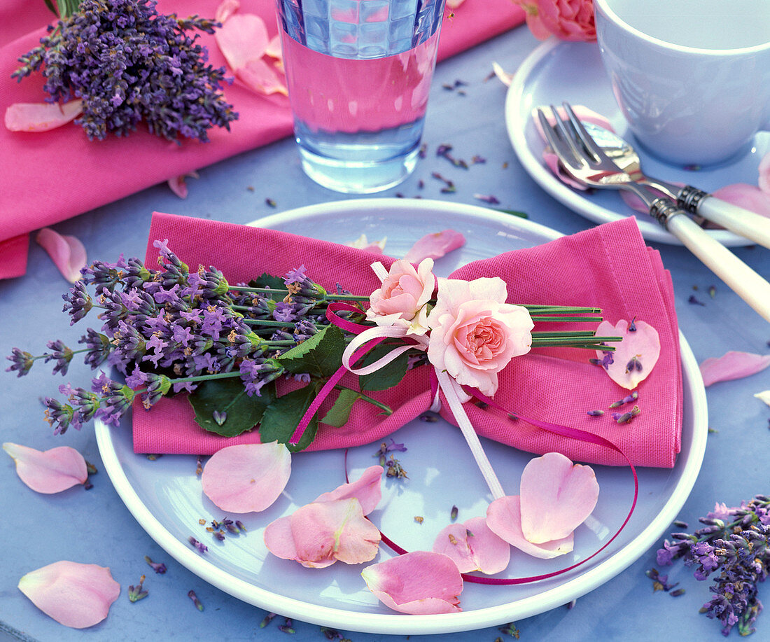 Sträußchen aus Lavandula (Lavendel) und Rosa (Rose) auf pinker Serviette