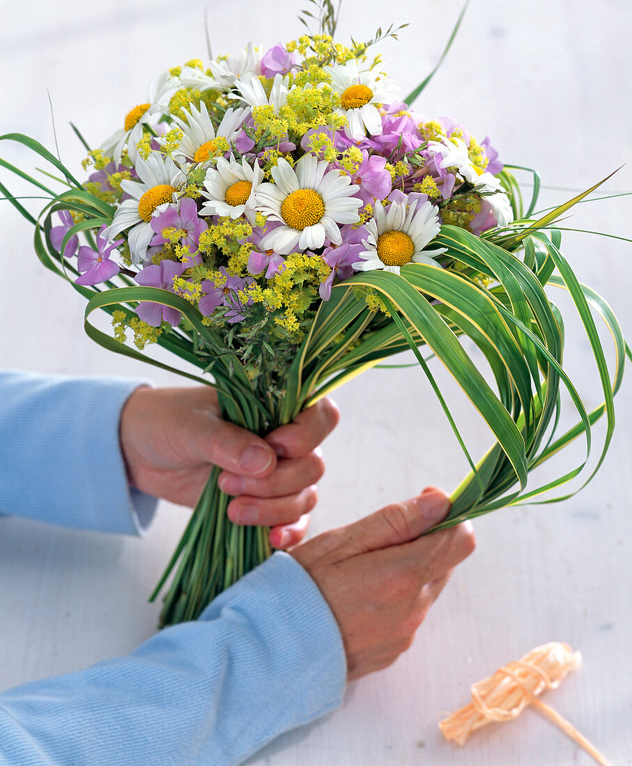 Hand bouquet with daisies and phlox