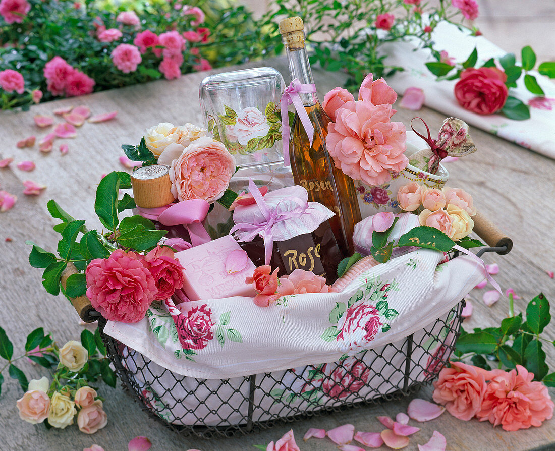 Geschenkekorb mit Blüten von Rosa (Rosen), Rosengelee, -likör, und -seife