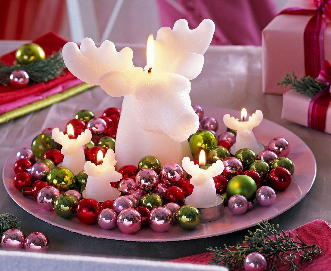 Big and small white moose candles on pink