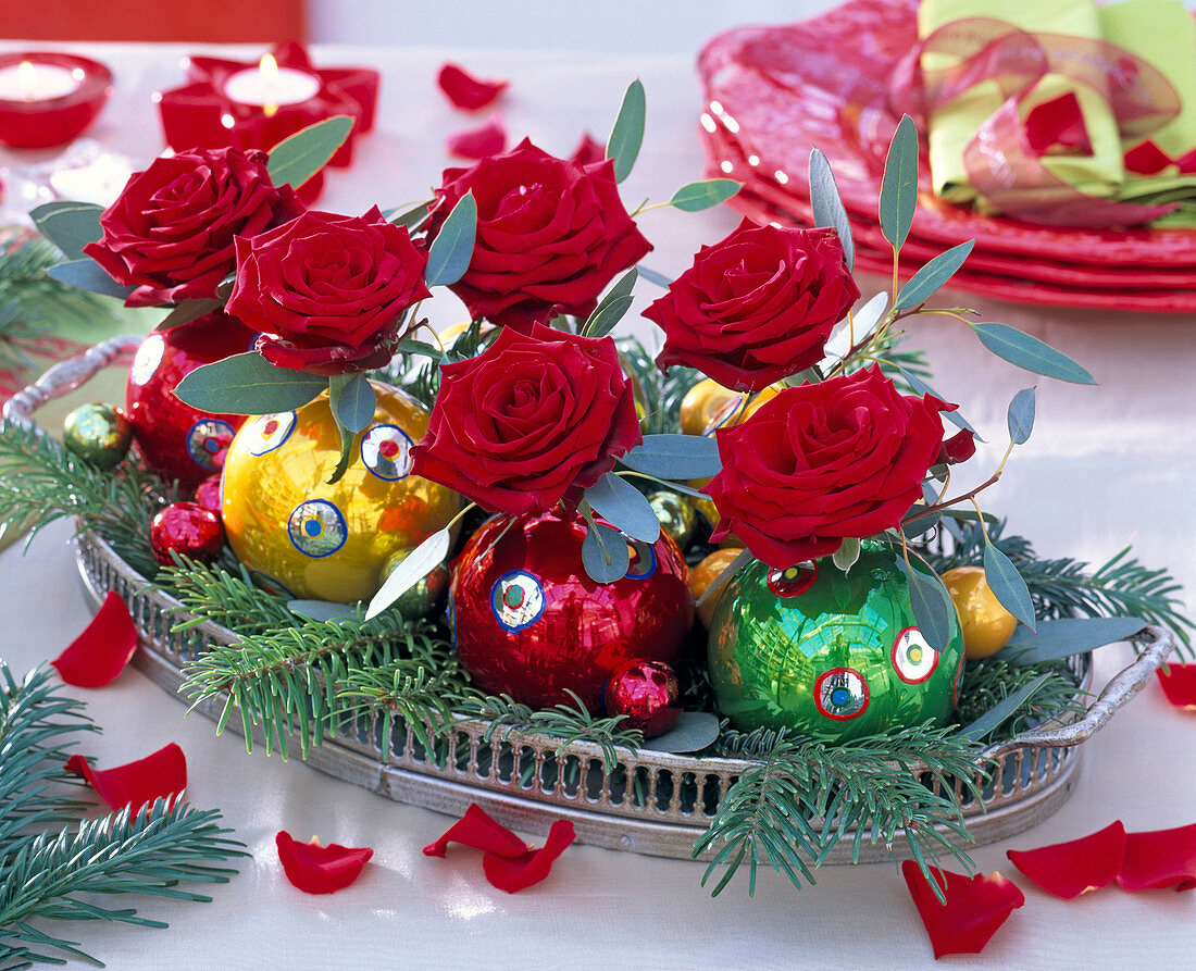 Rote Rosa 'Passion' (Rosen), Eucalyptus, in Weihnachtsbaumkugeln als Vasen