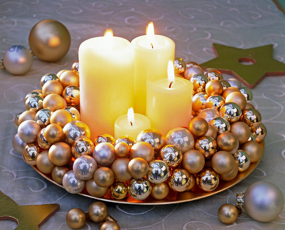 Adventskranz aus kleinen goldenen und silbernen Weihnachtsbaumkugeln mit weißen