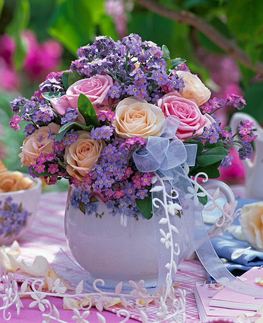 Bouquet of pink and myosotis with bow in jug