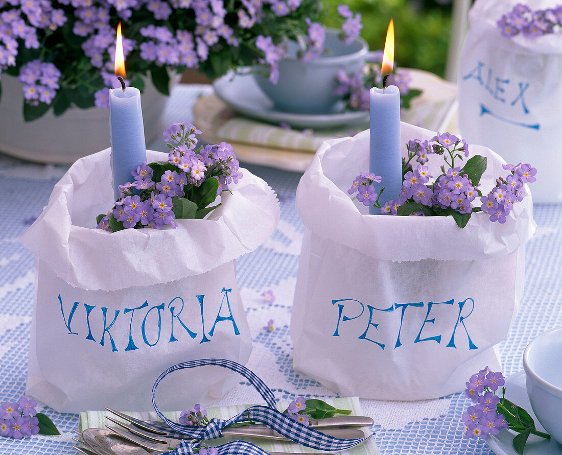 Myosotis in paper bags with blue candles as name tags