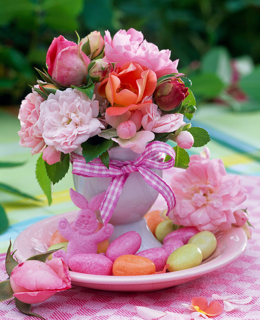 Small bouquet of different roses in egg cups on saucer