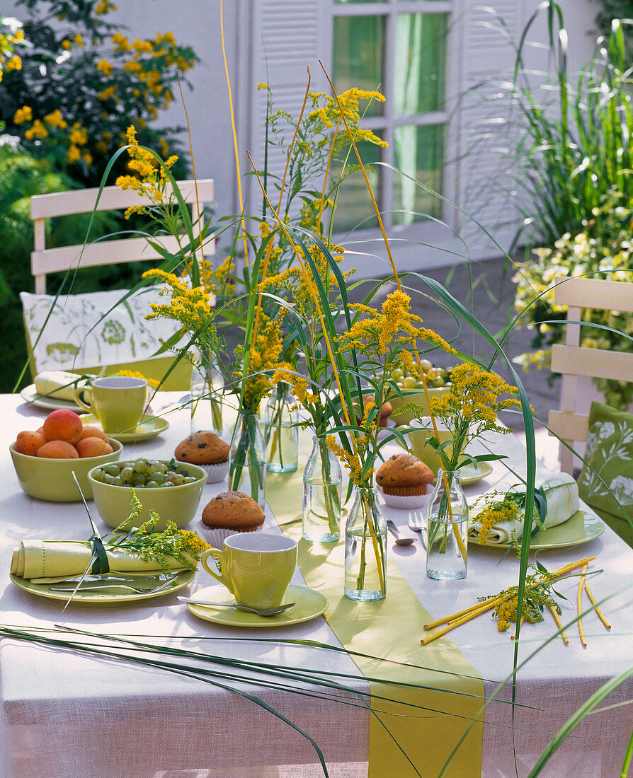 Table decoration with Solidago, grasses, yellow wicker, table settings