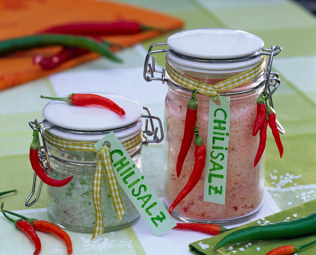 Kräutersalz mit Salz und Capsicum (Peperoni) in Einmachgläsern mit Etikett