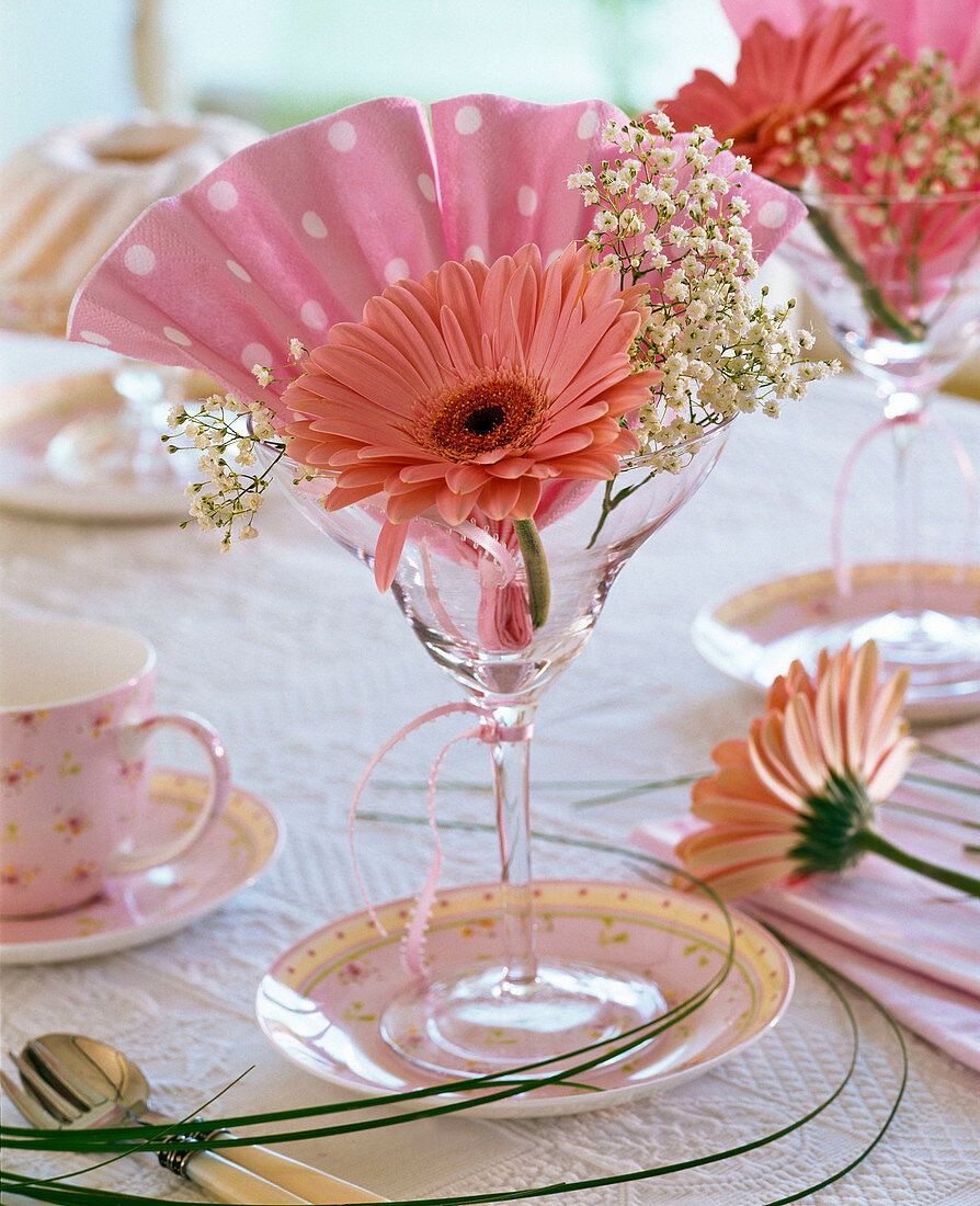 Gerbera und Gypsophila (Schleierkraut), fächerförmig gefaltete Serviette